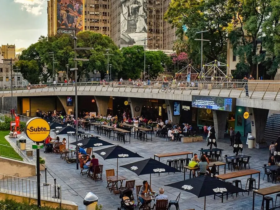 Paseo Houssay, con mesas y bicicletas frente a los edificios de la zona